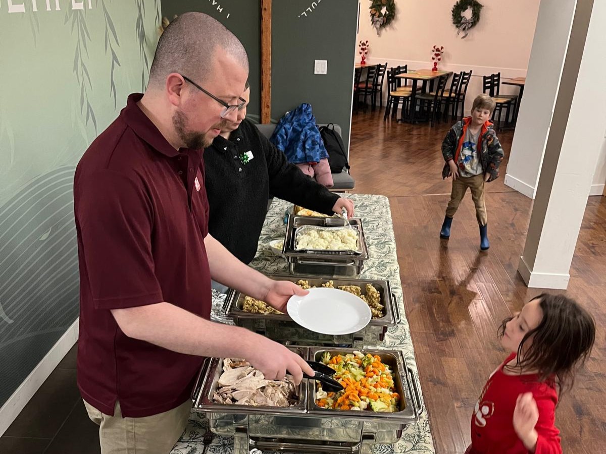 man serving food to child