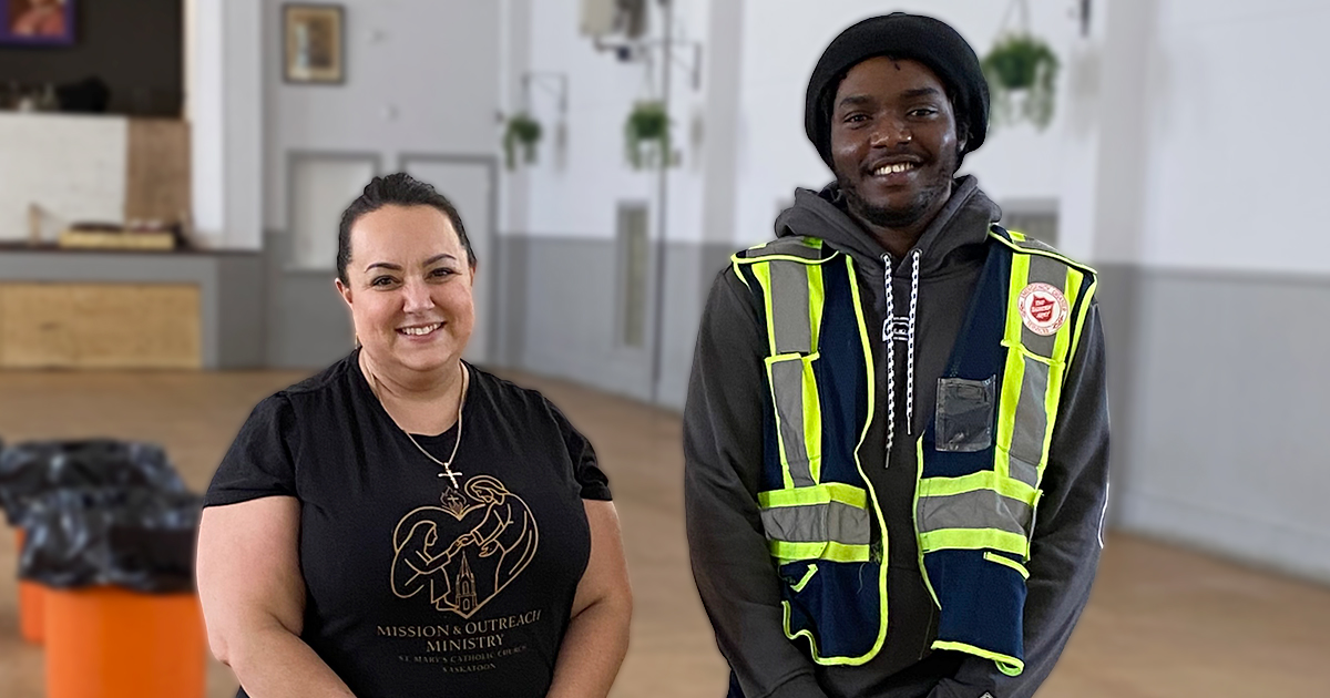 A woman and man stand together smiling